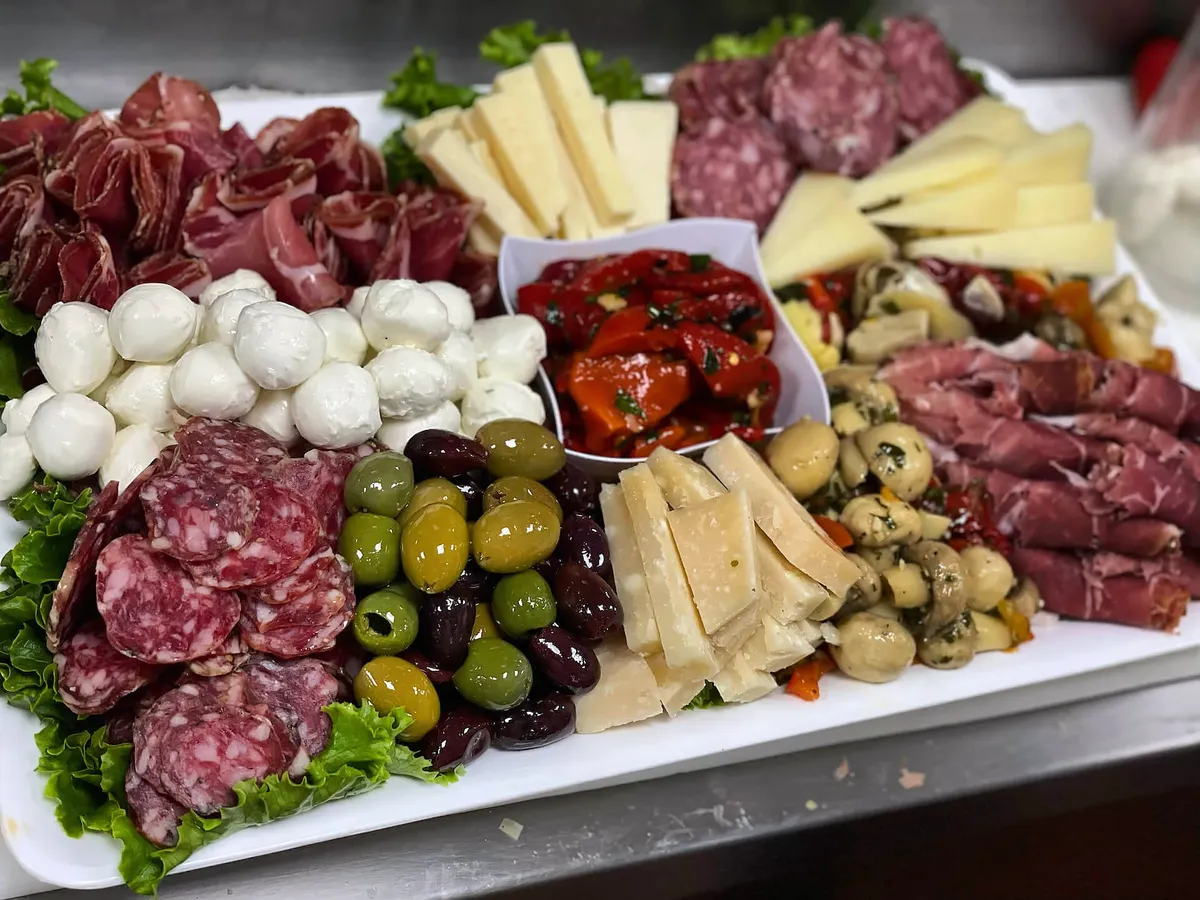 Antipasto platter of salami, mozzarella balls, provolone wedges, olives, roasted peppers and marinated mushrooms