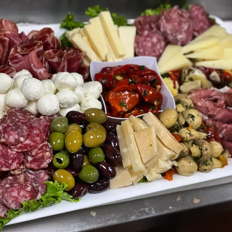 Antipasto platter of salami, mozzarella balls, provolone and parmesan wedges, green and black olives, roasted red peppers and marinated mushrooms